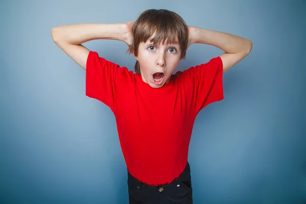 Boy teenager European appearance in a shirt opened his mouth sho — Stock Photo, Image