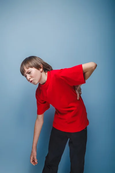 Teenager boy brown European appearance in a red shirt holding hi — Stock Photo, Image