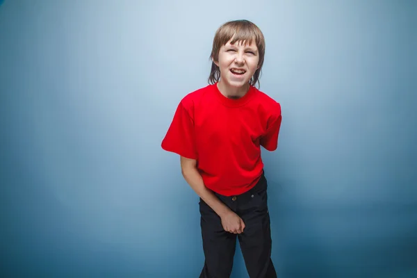 Teenager boy in red T-shirt European appearance brown hair holds — Stock Photo, Image