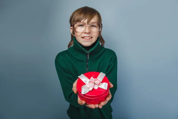 Европейский мальчик 10 лет в очках с подарочной коробкой — стоковое фото