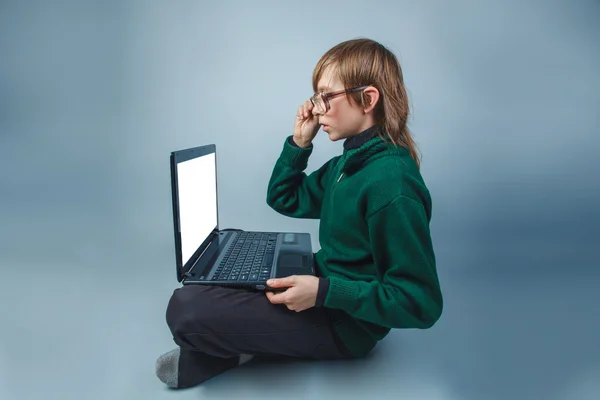 European-looking boy of  ten  years  in glasses sitting looking — Stock Photo, Image