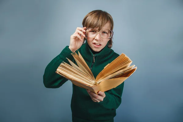 Europäisch aussehender Junge von zehn Jahren mit Brille liest ein Buch — Stockfoto