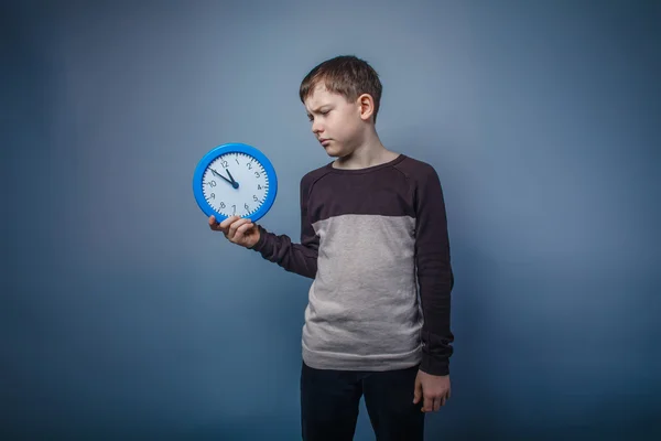 Jongen tiener Europees uiterlijk in bruin trui houden een blauw — Stockfoto