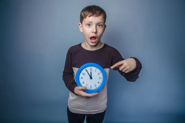 Jongen tiener Europees uiterlijk in bruin trui houden een blauw — Stockfoto