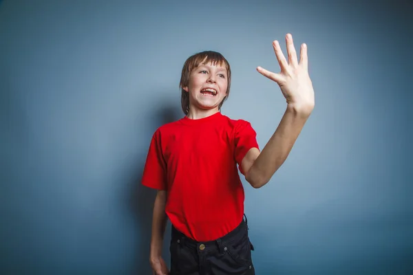 Teenager boy brown European appearance in a red shirt is pointin — Stock Photo, Image