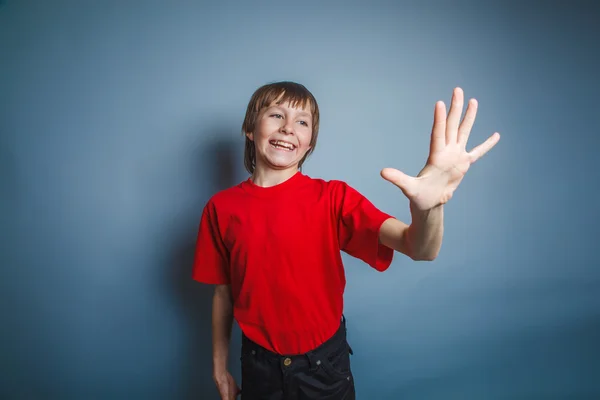 Teenager boy brown European appearance in a red shirt is pointin — Stock Photo, Image