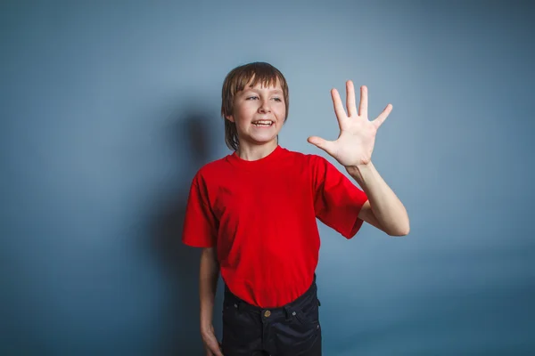 Teenager boy brown European appearance in a red shirt is pointin — Stock Photo, Image