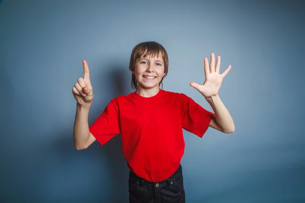 Adolescente menino marrom europeu aparência em uma camisa vermelha mostra o — Fotografia de Stock