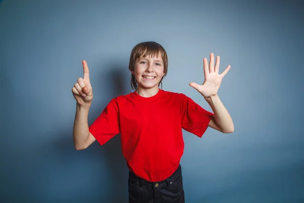 Teenager boy brown European appearance in a red shirt shows the — Stock Photo, Image