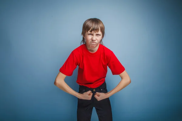 Adolescente chico marrón europeo apariencia en una camisa roja muestra el —  Fotos de Stock