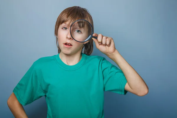 Tonåring pojke brun europeiskt utseende i en grön skjorta ser — Stockfoto