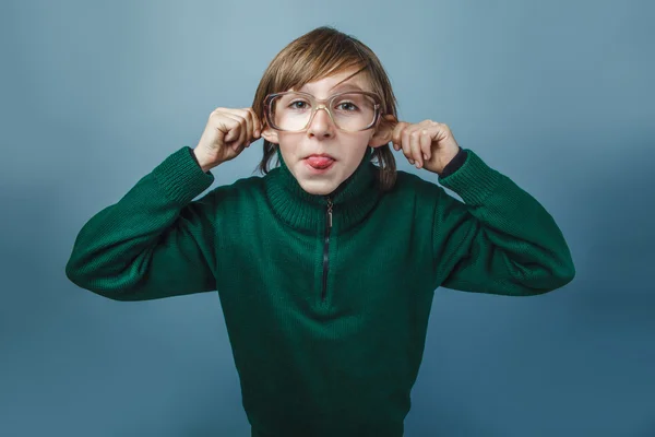 European-looking boy of ten years in glasses poses face shows to — Stock Photo, Image