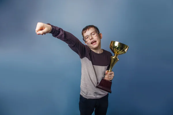 European-looking boy of ten years in glasses holding  a cup in h — Stock Photo, Image