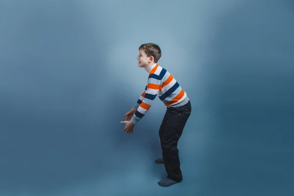 European-looking boy  of ten  years raises an invisible object o — Stock Photo, Image