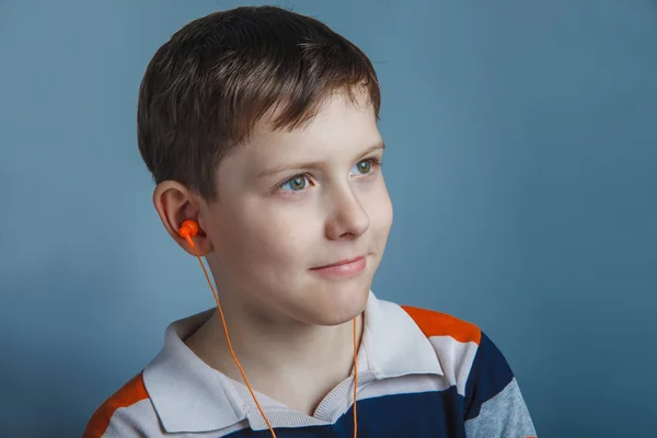 European-looking boy  of ten years with  headphones listening to — Stock Photo, Image