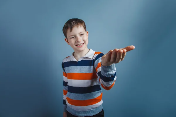 Europeo-looking ragazzo di dieci anni tira la sua mano richieste su un — Foto Stock