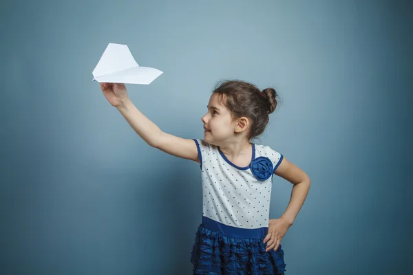 Uma menina de sete aparência europeia morena segurando um ar de papel — Fotografia de Stock