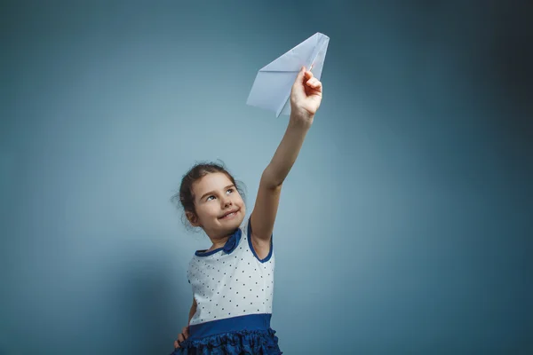 Una chica de siete aspecto europeo morena sosteniendo un papel de aire —  Fotos de Stock