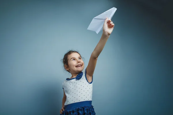 Una chica de siete aspecto europeo morena sosteniendo un papel de aire — Foto de Stock