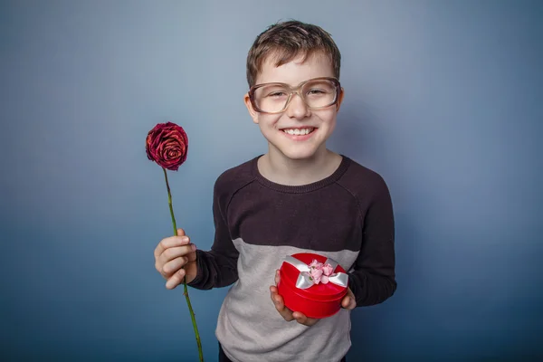 Pojke tonåring europeiskt utseende i solglasögon håller en gåva en — Stockfoto