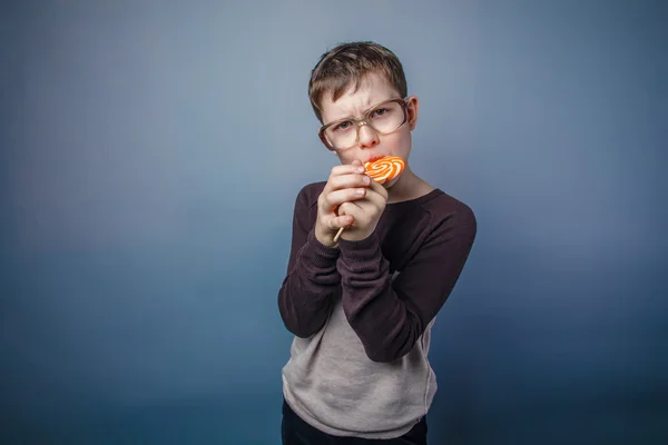 Şeker renkli çocuk genç Avrupa görünüm güneş gözlüklü yalıyor — Stok fotoğraf