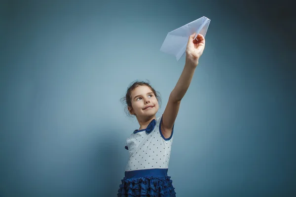 Uma menina de sete aparência europeia morena segurando um ar de papel — Fotografia de Stock