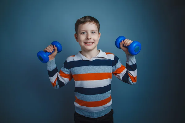Teenager boy brown European appearance holds a blue dumbbell on — Stock Photo, Image