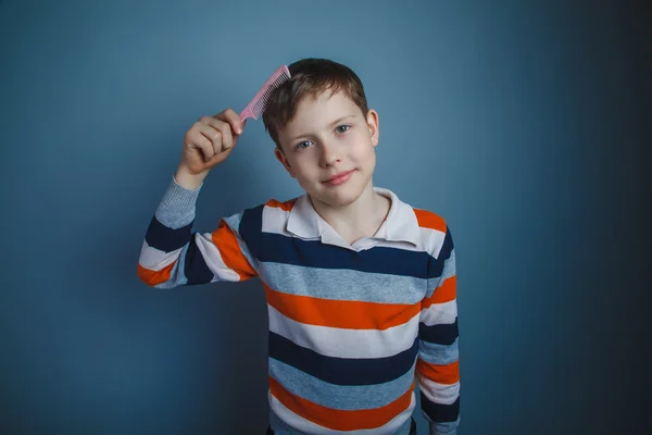 Teenager boy of about ten European appearance brown hair combs h — Stock Photo, Image