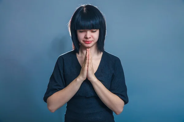 European appearance brunette girl clasped her hands in prayer an — Stock Photo, Image