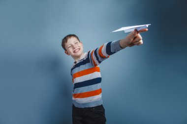 On yıllık kağıt uçak bir gr üzerinde oynarken Avrupa görünümlü oğlan