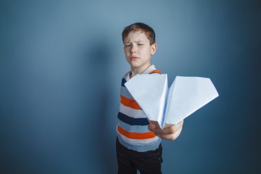 çocuk genç Avrupa görünüm kahverengi bir kağıt uçak başlattı