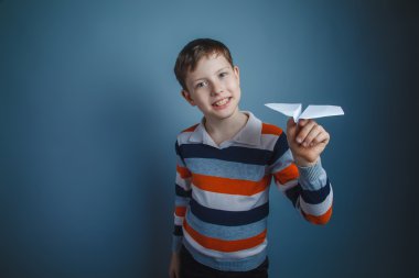 çocuk genç Avrupa görünüm kahverengi bir kağıt uçak başlattı