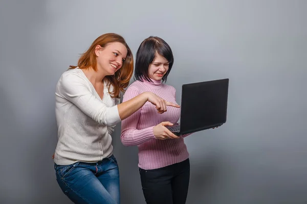 Två flickor europeiskt utseende flickvän tittar på datorn — Stockfoto