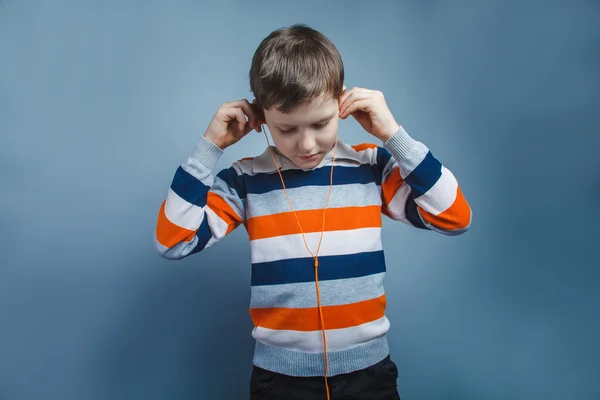 Europäisch aussehender zehnjähriger Junge hört Musik mit Kopfhörer — Stockfoto