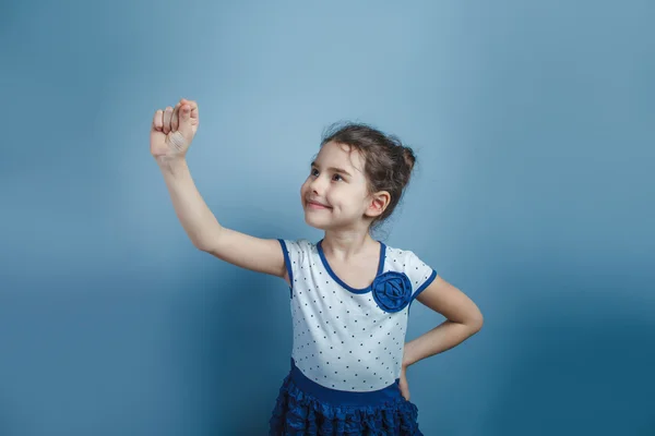 Evropská vypadající dívka pěti let nakreslí do vzduchu na šedém pozadí — Stock fotografie