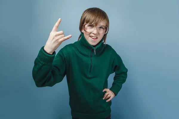 Chico de aspecto europeo de diez años mostrando pulgares hacia arriba en un gris — Foto de Stock