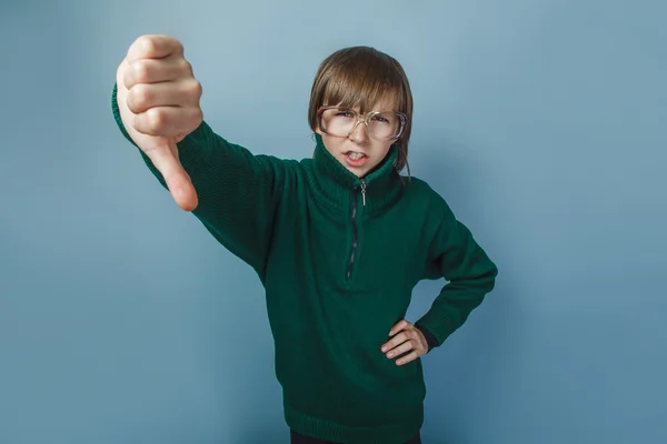 European-looking boy of ten years showing thumbs down on a black — Stock Photo, Image