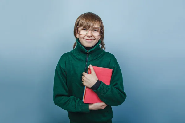 Европейский мальчик 10 лет в очках с книгой в руках — стоковое фото