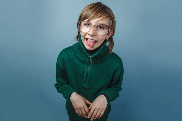 Europeiska-ser pojke på tio år i glas visar tungan på — Stockfoto