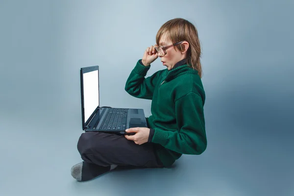 European-looking boy of  ten  years  in glasses sitting looking — Stock Photo, Image