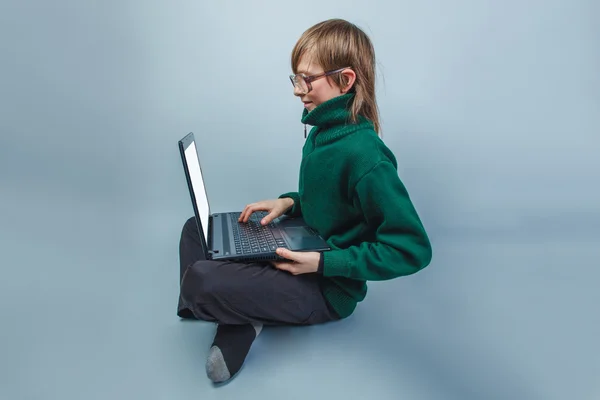 European-looking boy of  ten  years  in glasses sitting looking — Stock Photo, Image