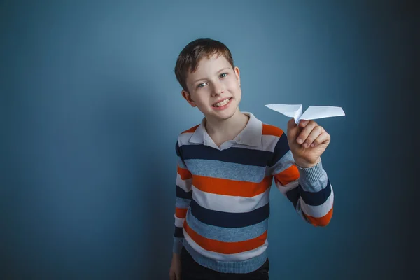 Boy teenager European appearance Brown launches a paper airplane — Stock Photo, Image