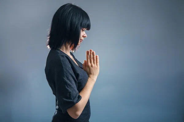 European appearance brunette woman folded her hands in prayer on — Stock Photo, Image