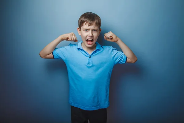 Dospívající chlapec hnědé evropských vystoupení v modré tričko ukazuje — Stock fotografie