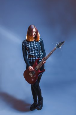Avrupa görünüm saçlı kız mavi kazaklı gitar çalmak
