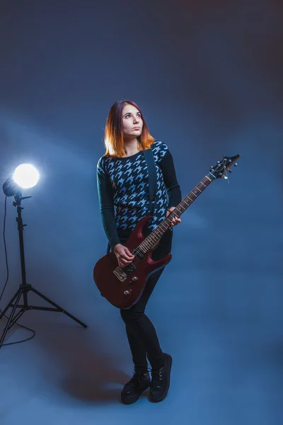 Ευρωπαϊκής εμφάνιση μαλλιά κορίτσι σε ένα μπλε πουλόβερ που παίζει κιθάρα — Φωτογραφία Αρχείου