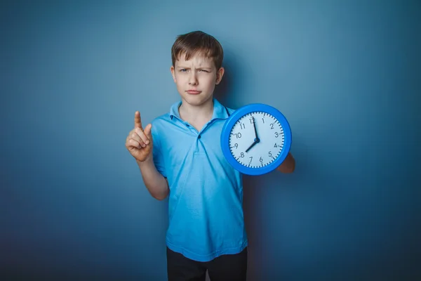 Teenager boy Brown European appearance in a blue shirt holding a — Stock Photo, Image