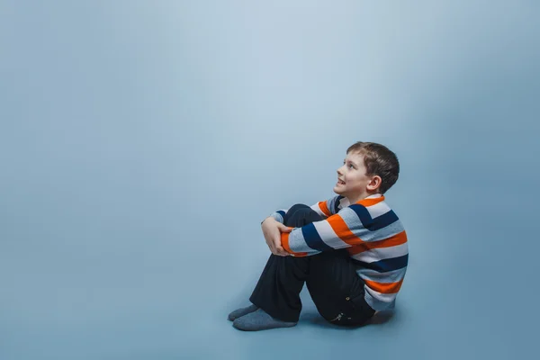 Ragazzo adolescente aspetto europeo dieci anni è seduto sul — Foto Stock