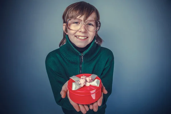Европейский мальчик 10 лет в очках с подарочной коробкой — стоковое фото