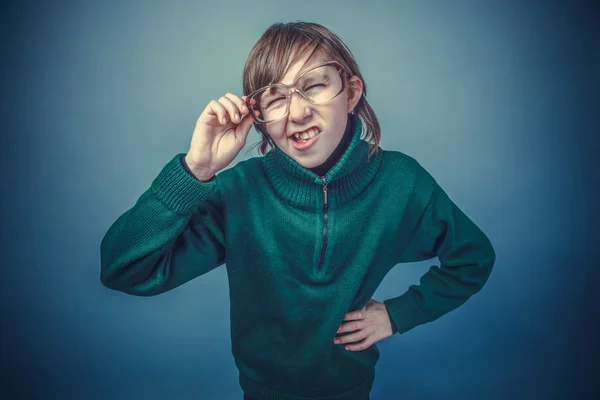Ευρωπαϊκή εμφάνιση αγόρι δέκα ετών σε γυαλιά squints σε ένα γκρι β — Φωτογραφία Αρχείου